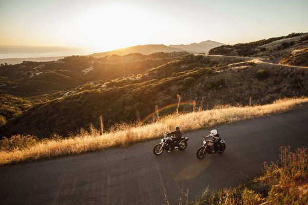 Two friends riding motorcycles together on country roads, Santa Barbara County, California, USA